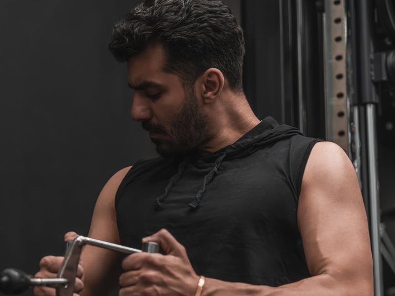 Man performing power exercise in a dark gym environment.